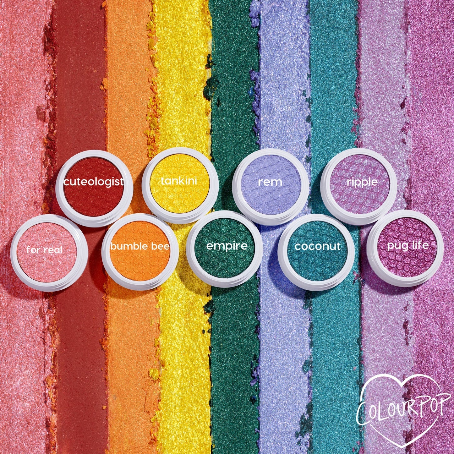 Empire Super Shock Shadow by ColourPop glows as a metallic emerald single in a white pot, centered on a flat lay of rainbow shimmer swatches and companion shades, showcasing rich green payoff and bouncy cream-to-powder texture.