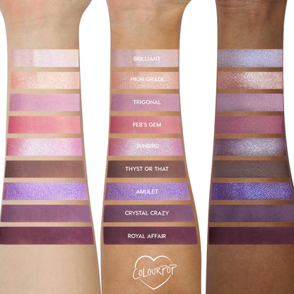 Arm swatches show the All Amethyst ColourPop Shadow Palette on three skin tones, displaying nine lilac, pink, and deep plum shades in matte and shimmer - e.g., Brilliant, Feb’s Gem, Royal Affair - with labeled stripes for color payoff comparison.
