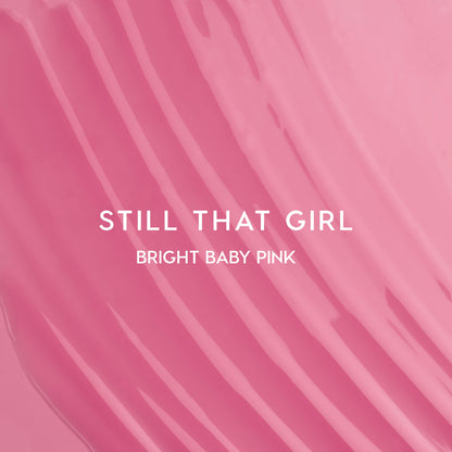 Still That Girl Ultra Glossy Lip Heart to Get swatch showing smooth, bright baby pink lip gloss spread in soft ridges across a solid pink background, highlighting its high-shine, creamy texture for bold, glossy lips.