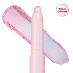 Colourpop Disco Disco Shadow Stix shown uncapped with its shimmery iridescent pink and icy blue eyeshadow swatch smeared diagonally behind the pale pink twist-up stick on a white background.